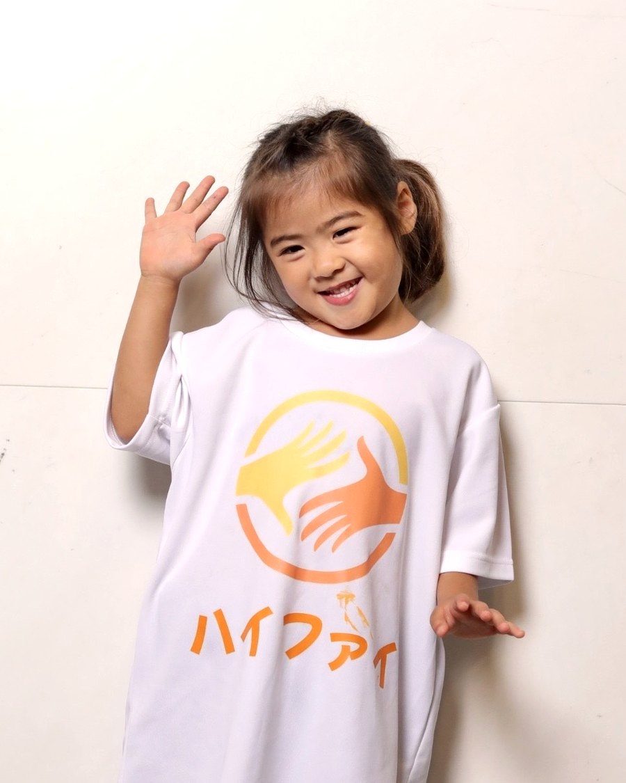 ハイファイのTシャツを着て笑顔で手をふる女の子